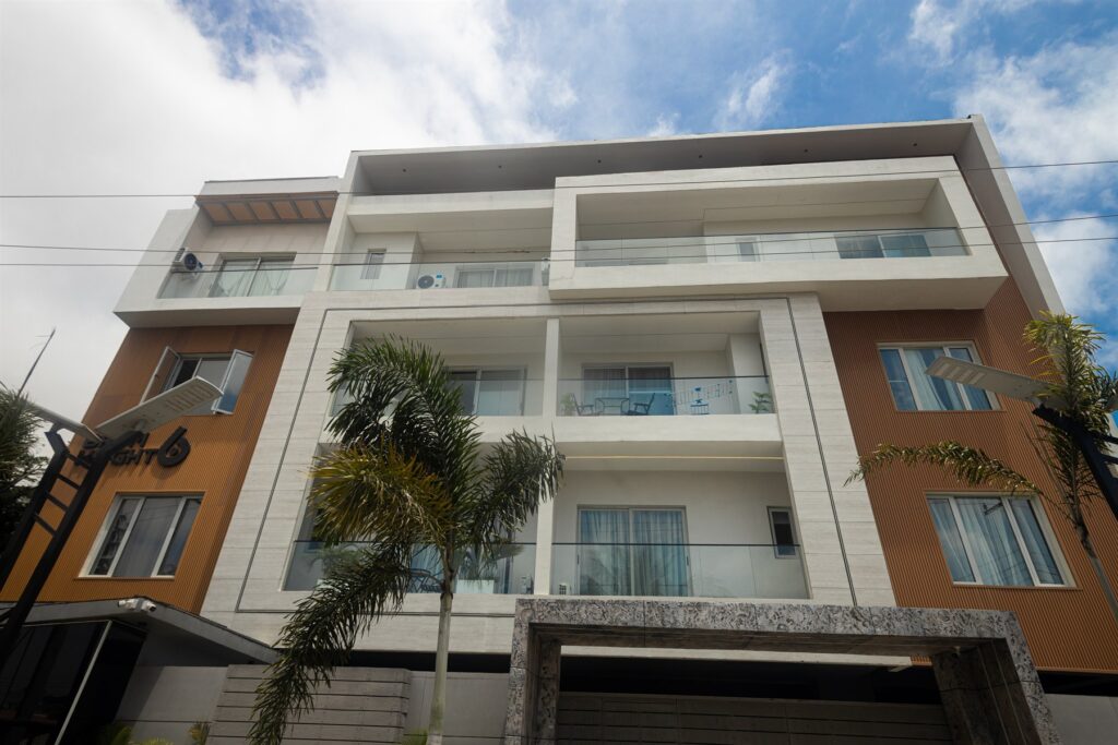 Brum Height 6: Front facade with glass balcony railings and palm planting